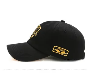 Detail view of black cotton baseball cap showing yellow FORCE wing embroidery on the side