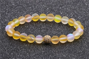 Bracelet de perles pierre de lune 8mm avec breloque boule pavée dorée sur fond gris