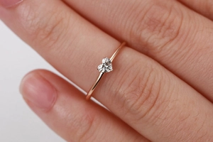 Primo piano dell'anello con zircone a cuore in oro rosa con fascia sottile al dito