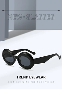 Detail view of bold black oval sunglasses with wide temples and high-quality finish