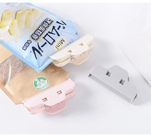 Detail showing colorful large plastic food clips sealing snack bags on white background