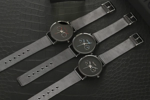 Vue détaillée de trois montres à quartz avec bracelets en maille et aiguilles de couleurs