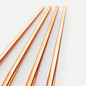 Set of 4 rose gold makeup brushes with glossy metallic handles on white background