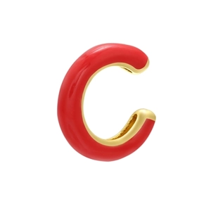 Dettaglio di un earcuff a C dorato con finitura in smalto rosso su sfondo bianco