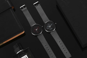 Detail view of quartz watch with blue and red hands on silver Milanese mesh strap