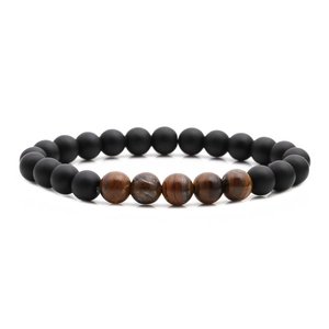 Detailed macro view of matte black beads and five tiger eye stones on a beaded bracelet