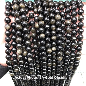 Macro shot of 5A golden obsidian beads with metallic shimmer and cat eye effect