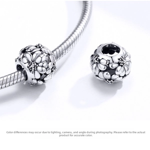 Macro view of 925 sterling silver daisy flower charm beads on a snake chain bracelet