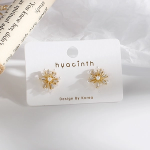 Sparkling snowflake earrings with white pearls and cubic zirconia on gold studs