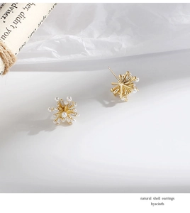 Detail of elegant snowflake earrings featuring radiant pearls and sparkling zircons