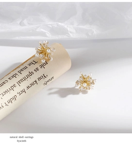 Detailed macro shot of elegant snowflake stud earrings with pearls and crystals