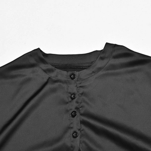 Détails du haut en satin noir montrant le col rond et les boutons à quatre trous