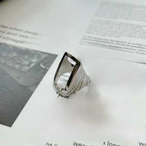Detailed view of wide hollow geometric 925 silver ring on an editorial background