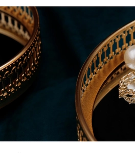 Macro shot of vintage gold镂空 mirror jewelry tray with pearls and metal ornaments