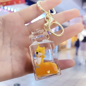 Detailed view of Shiba Inu acrylic soda bottle keychain with orange liquid and star sequins