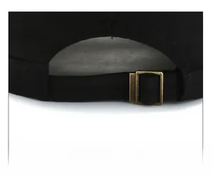 Detail of black cotton cap showing adjustable metal buckle and back strap system
