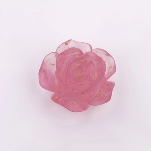Detailed macro view of a pink resin rose bead with embedded gold foil flakes