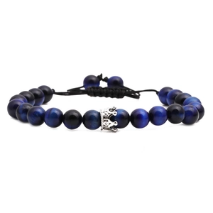 Blue tiger eye beaded bracelet with silver crown charm on adjustable black woven cord