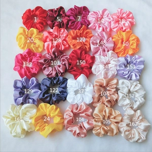 Close-up of 25 colorful satin hair scrunchies displayed in a neat 5x5 grid layout