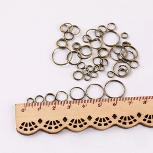 Macro shot of assorted bronze jump rings with scale ruler for DIY jewelry making