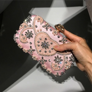 Pink evening clutch bag with pearl floral embroidery and golden rose clasp detail