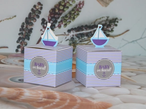 Detail view of nautical baby shower candy boxes with sailboat decor and anchor design