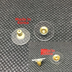 Macro shot of gold brass bullet earring backs with clear plastic disc pads for DIY jewelry