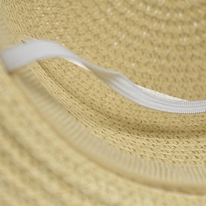 Detail of hand-woven straw hat interior with durable white elastic chin strap for wind protection