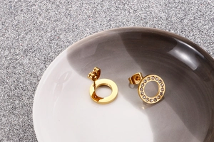 Detailed view of rose gold hollow circle studs with zircon inlay and butterfly backing