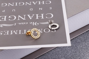 Detail of rose gold crystal-paved and silver circle stud earrings with metal backs