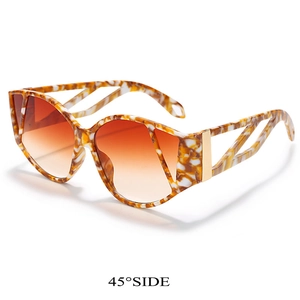 Detail of tortoise frame sunglasses with gradient orange lenses and metal hinges