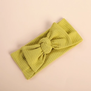 Macro detail of soft ribbed yellow baby headband with large elastic knit bow