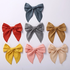 Detail showing seven colors of cotton linen bow clips for girls in high studio quality