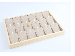 Detail of wooden jewelry display tray with 18 beige velvet slots for necklaces