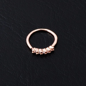 Rose gold flower stud earring with sparkling zircon stones on a black leather background