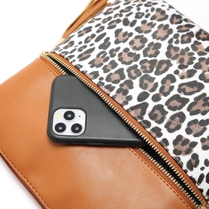 Detail of leopard print crossbody bag with tassel and pocket showing phone storage