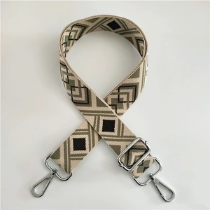 Detail of adjustable cotton strap with green geometric pattern and silver metal hooks