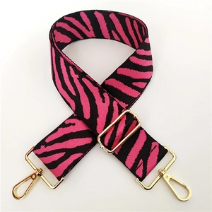Detail of zebra pattern wide canvas bag strap with pink stripes and gold metal hooks