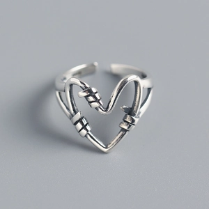 Detail of 925 sterling silver heart ring featuring unique wire-wrapped texture and open band
