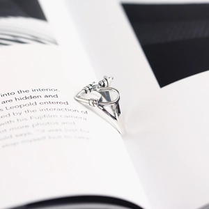Close-up of a handmade 925 silver heart wire ring on an open book background