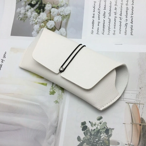 Minimalist white faux leather glasses pouch with black elastic cord and metal rivet detail
