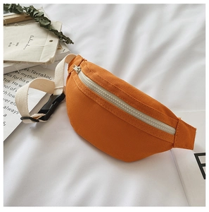 Detail of vibrant orange canvas waist bag with white zipper and woven strap on soft fabric