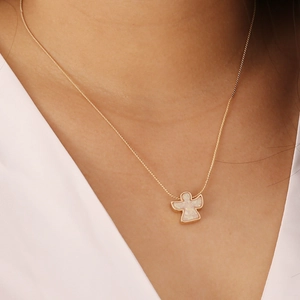 Detailed view of an angel pendant necklace with white opal inlay and a gold-plated chain