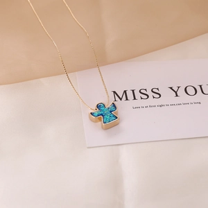 Detail view of a gold necklace featuring a blue opal angel pendant on a soft background