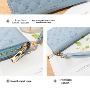 Detail view of light blue leather wallet showing smooth metal zipper and wrist strap