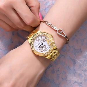 Gold Geneva watch with diamond butterfly dial and matching bracelet worn on wrist