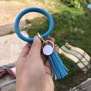 Detail of royal blue PU leather ring keychain with gold hardware and tassel charm