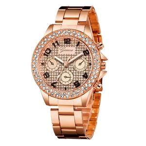 Detail of rose gold watch featuring crystal-encrusted bezel and metallic link bracelet