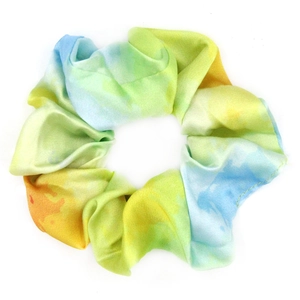 Close-up of colorful tie-dye fabric scrunchie in vibrant yellow, green, and blue silk texture