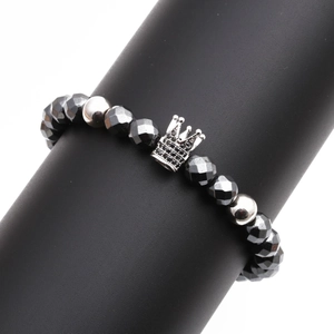 Faceted black hematite beaded bracelet featuring a silver crown charm on a display stand